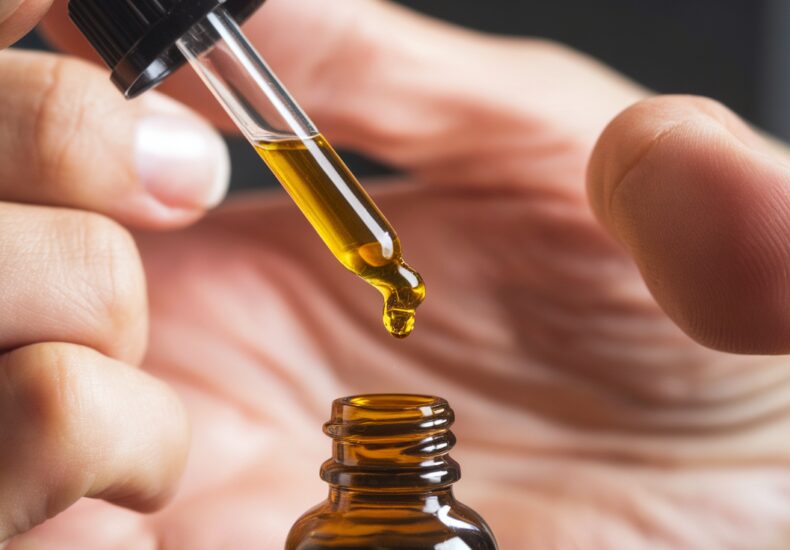 A bottle of CBD oil with hemp leaves
